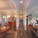 dining and living area with hardwood floors, white coffered ceilings, and fireplace decorated with Christmas stockings.